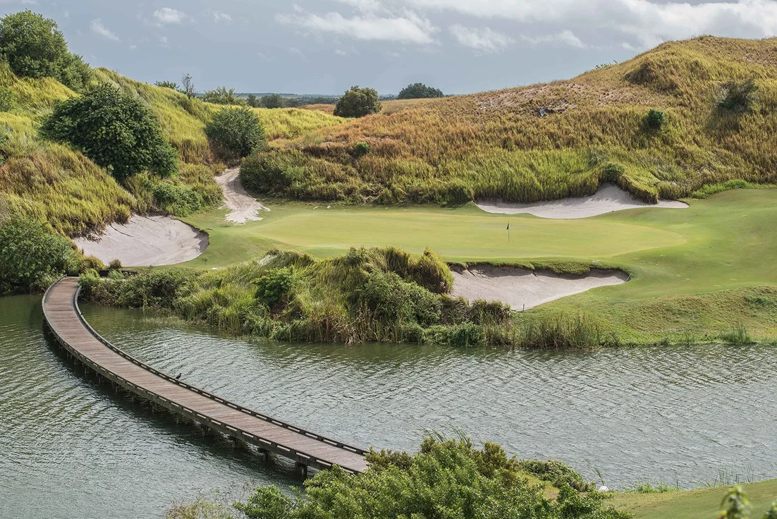 A peaceful golf course with a wooden bridge