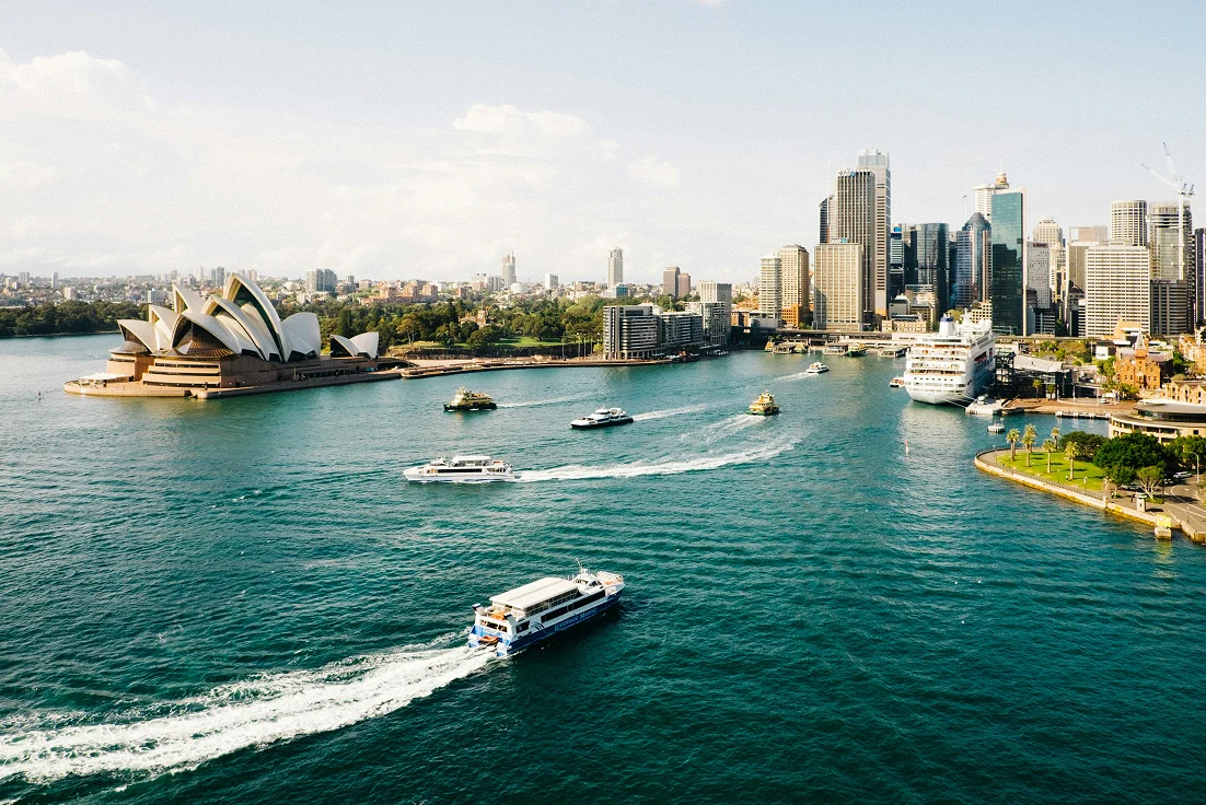 Water leading into sydney with boats and the sydney skyline